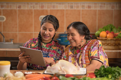 photo of a Native grandmother and granddaughter cooking