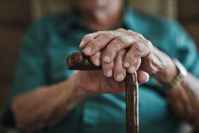 photo of older mans hands on a cane